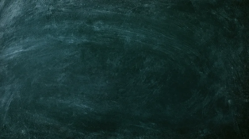 Close-up of a worn dark green chalkboard surface with smudged chalk marks and swirls, flat lay view