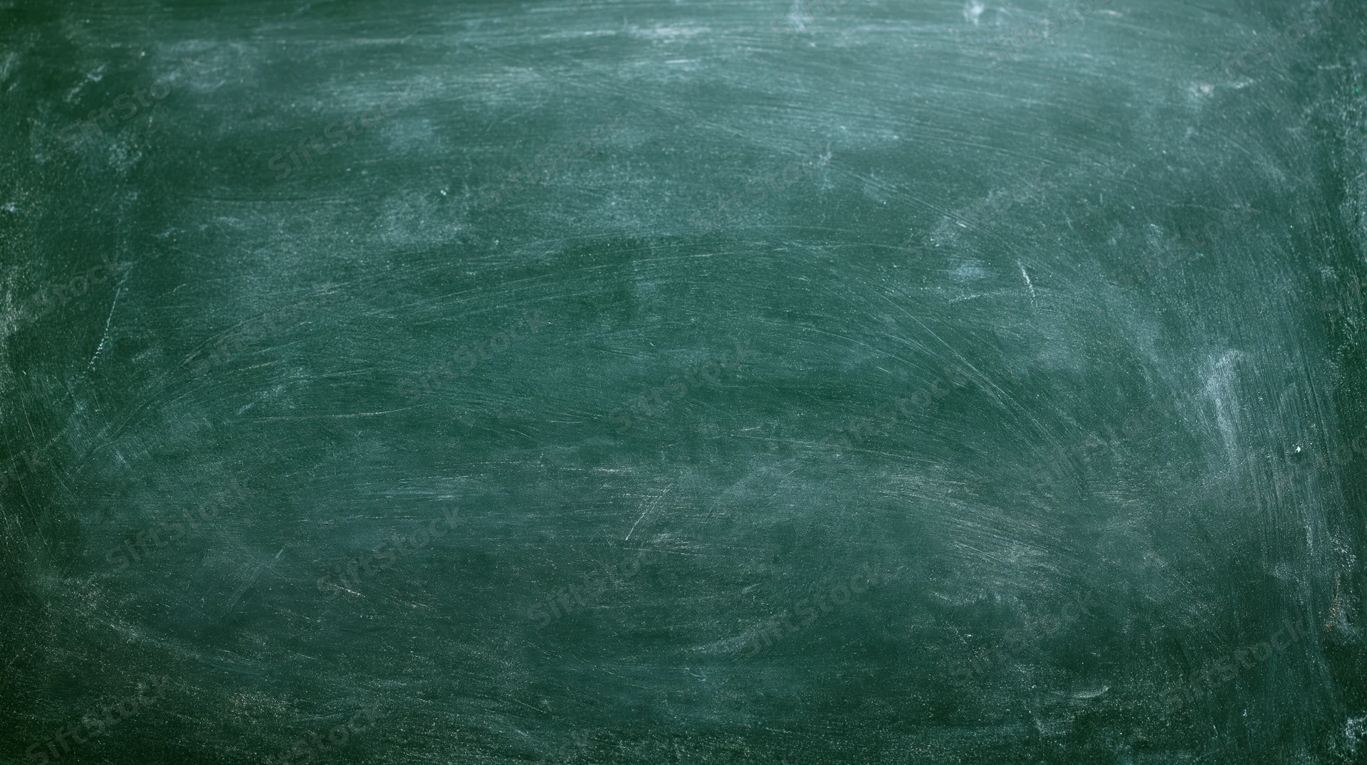 Close-up of a worn dark green chalkboard surface with smudged white residue and scratches