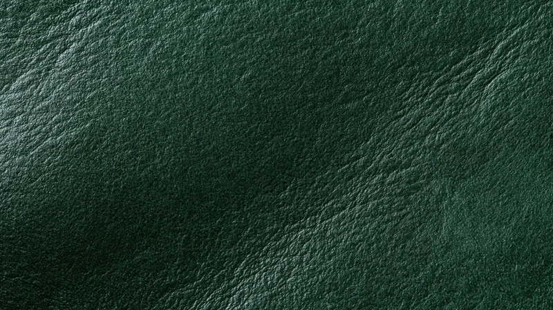 Close-up of dark forest green leather surface with visible grain and texture