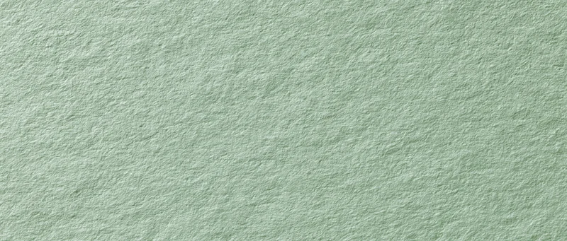 Close-up of muted sage green textured paper surface