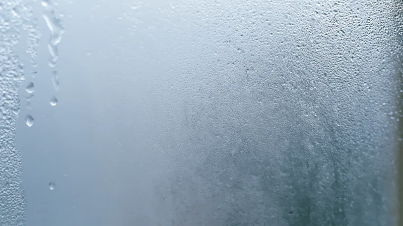 Close-up of fogged glass with water droplets and condensation on a window surface