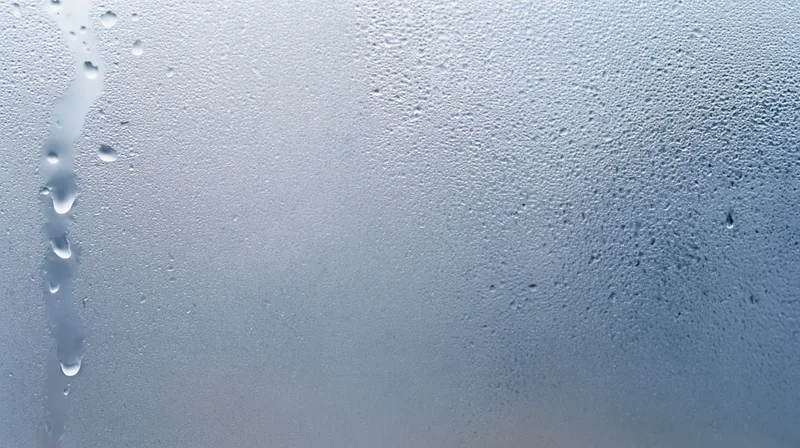 Close-up of water droplets and fog on a glass window surface