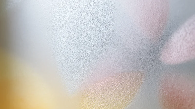 Close-up of frosted glass surface with diffused light and soft pastel colors