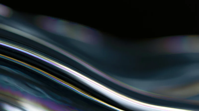 Flowing dark liquid glass surface with iridescent light reflections in macro closeup