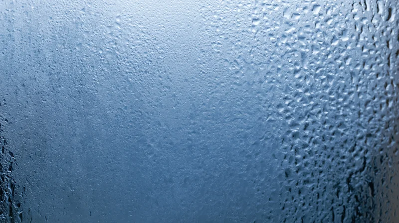 Close-up of water droplets on a fogged glass window surface
