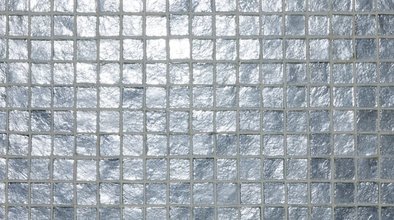 Close-up of silver mosaic tiles arranged in a grid on a wall surface