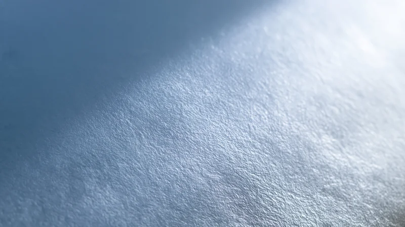 Close-up of frosted glass surface with soft light and blue-white gradient