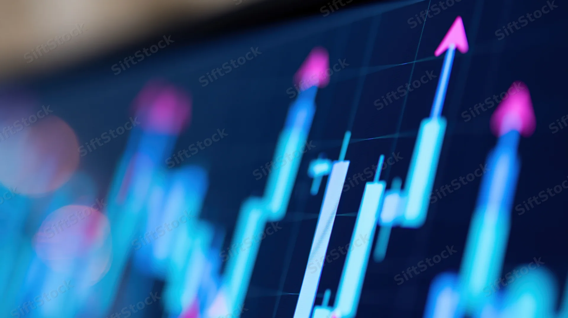 Close-up of a financial candlestick chart on a digital screen showing upward trend with pink arrows
