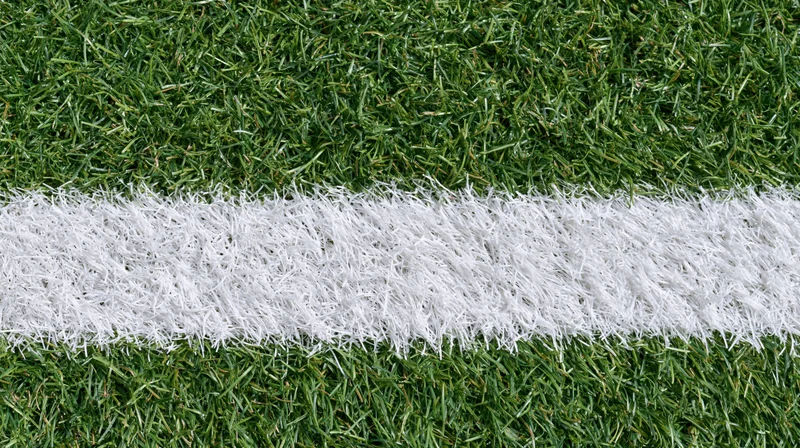 Close-up overhead view of white line on artificial turf sports field