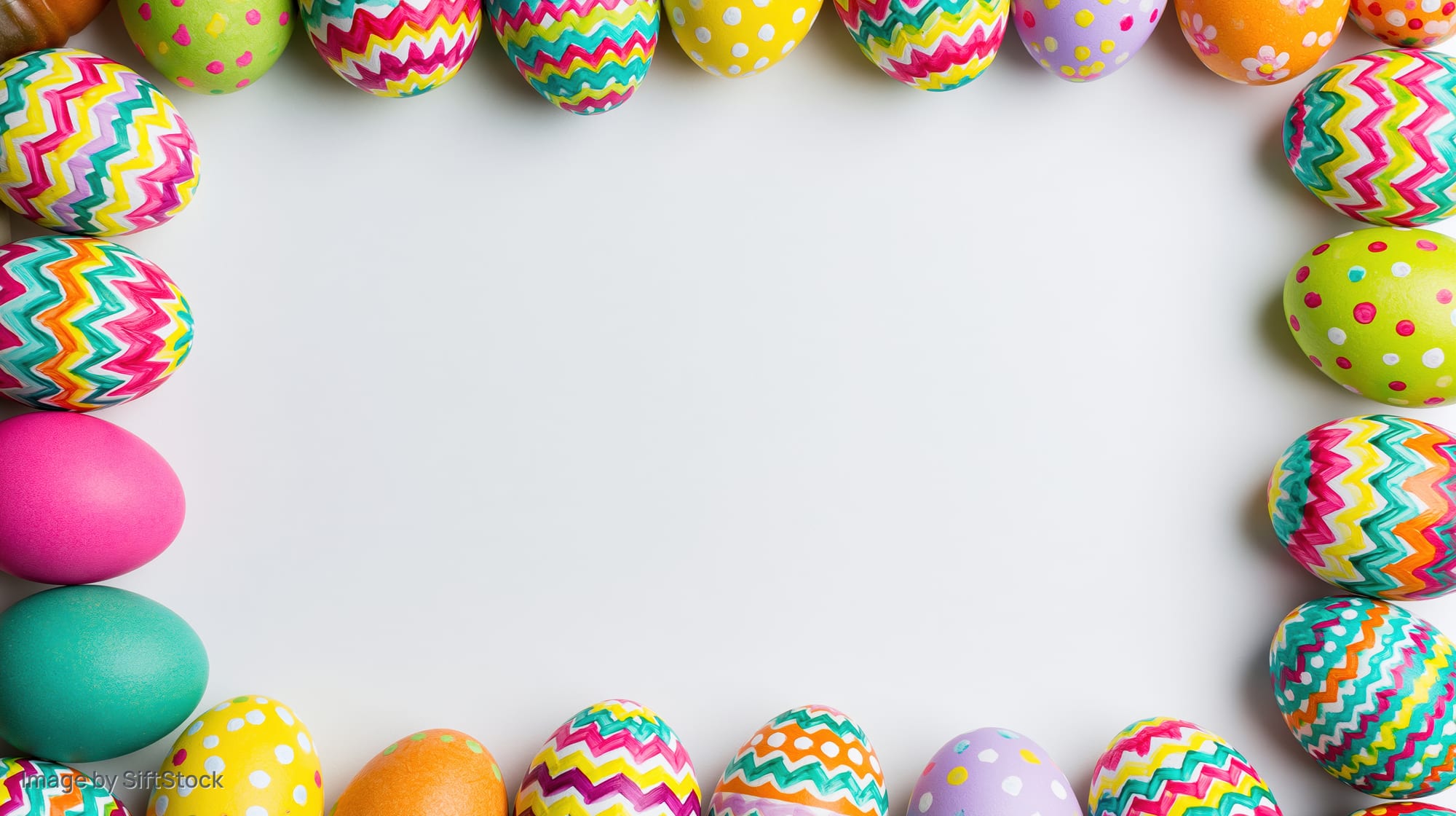 Colorful painted easter eggs arranged in a border frame on white background with copyspace