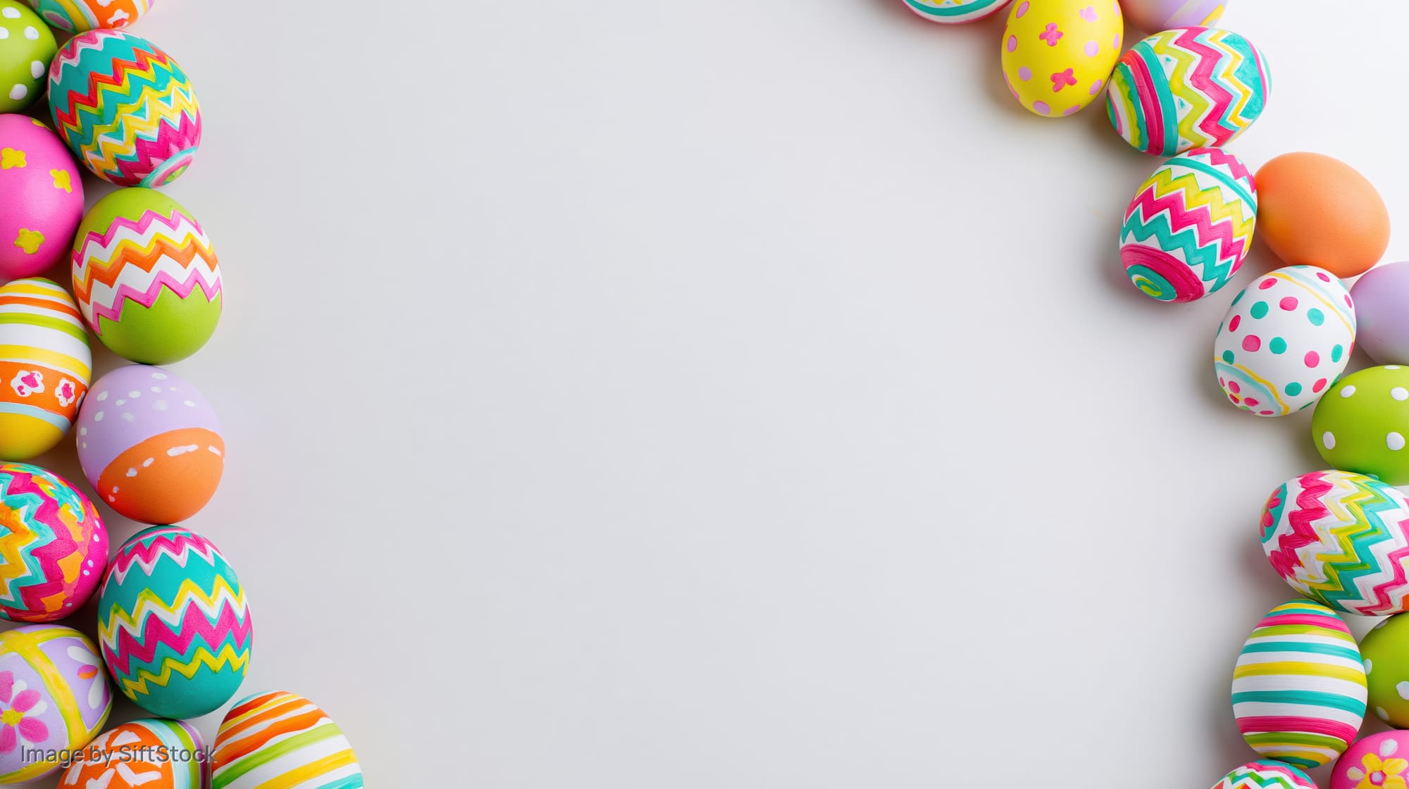 Colorful painted easter eggs arranged in two vertical borders on white background with copyspace
