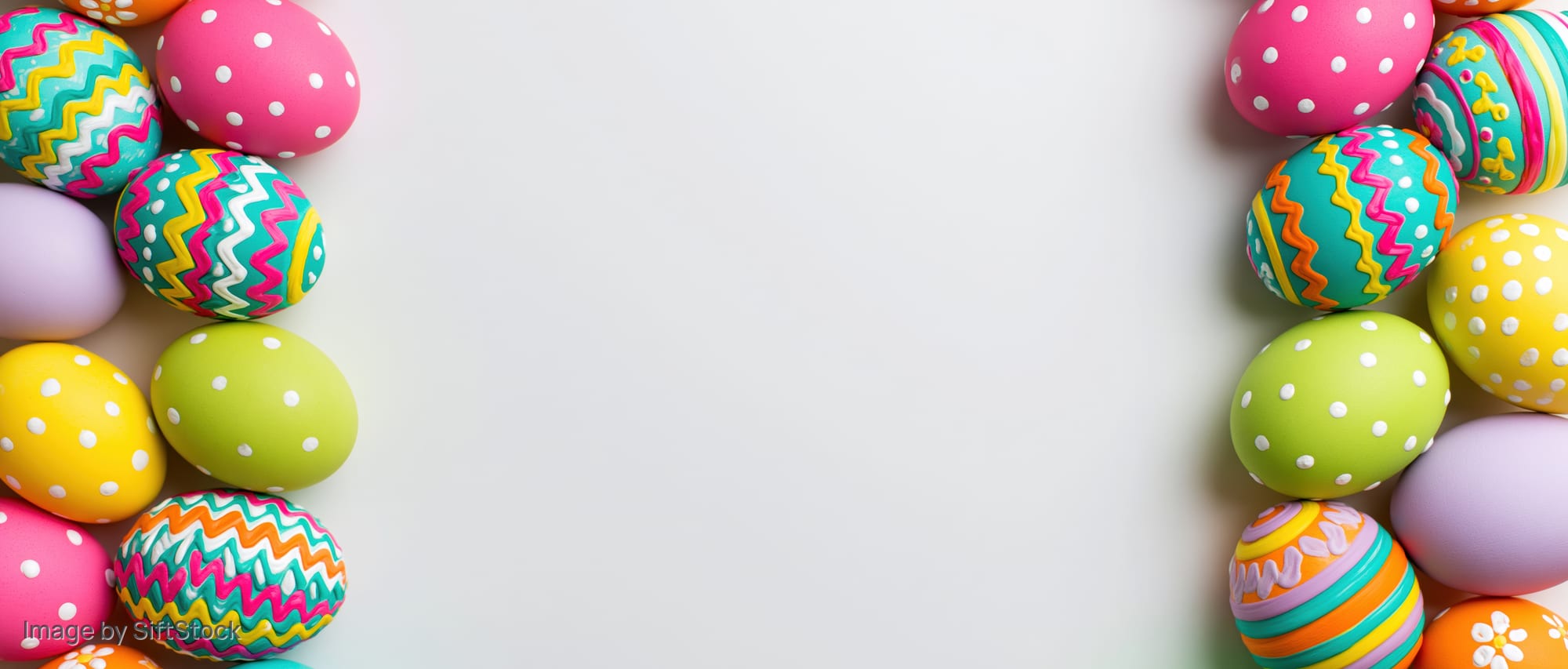 Colorful painted easter eggs arranged in two vertical borders on white background with copyspace