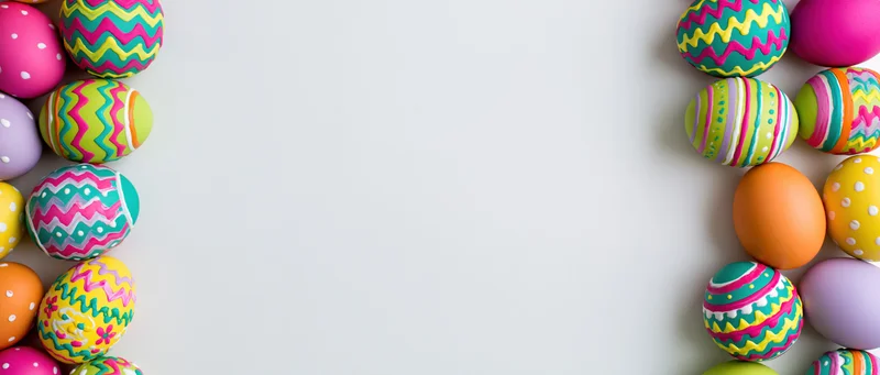 Colorful painted easter eggs arranged in two vertical borders on white surface with central copyspace