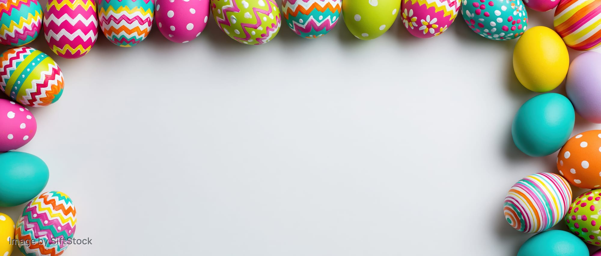 Colorful painted easter eggs arranged in vertical borders on white surface with copyspace