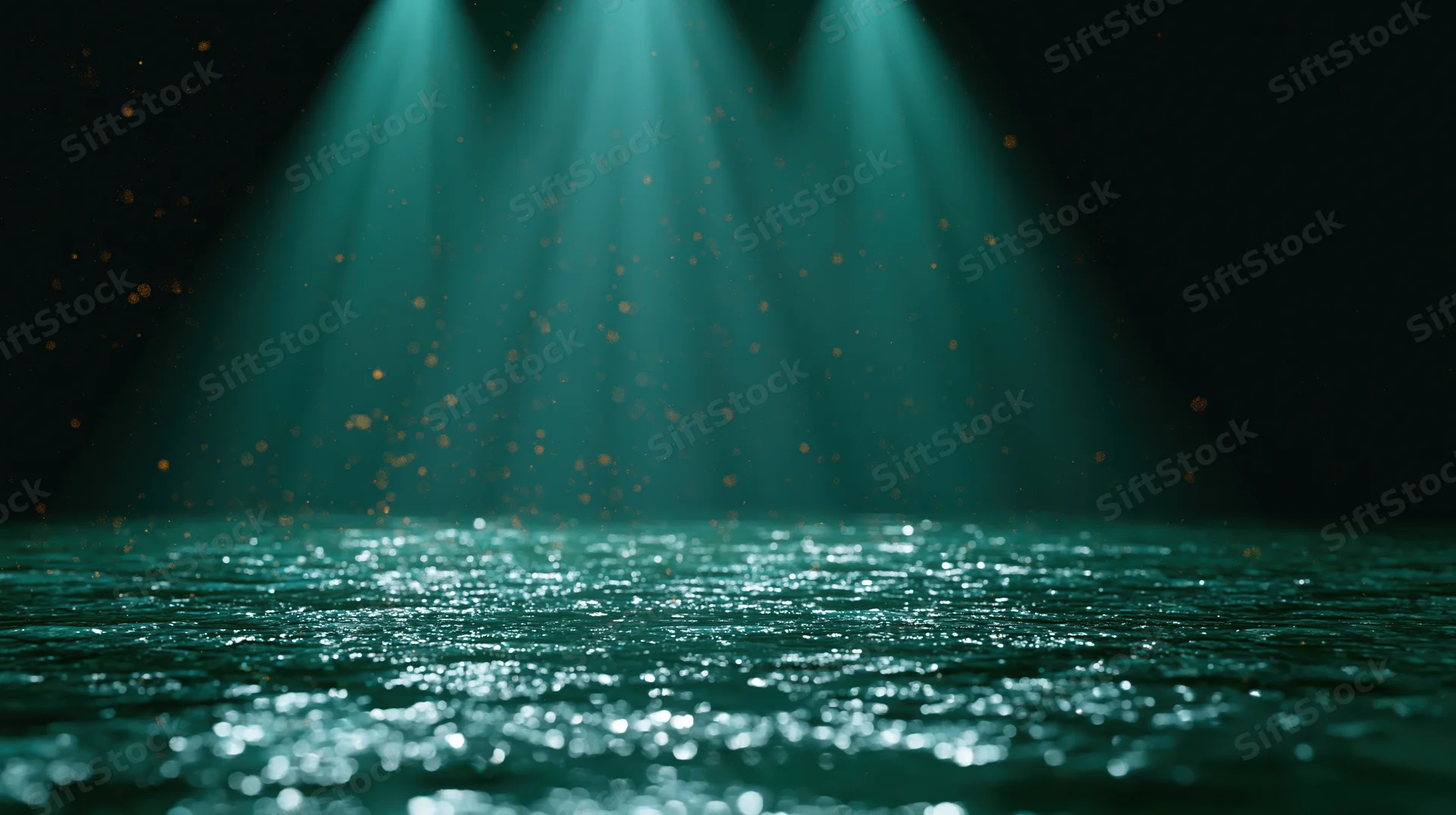 Teal spotlights shining on a dark stage floor with sparkling reflections and floating particles