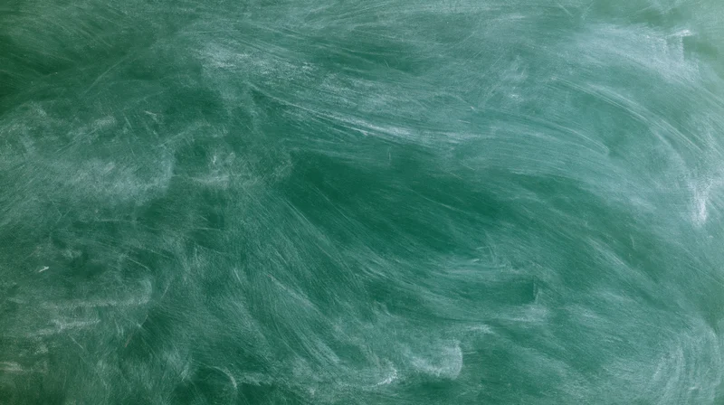Green chalkboard surface with erased white chalk marks filling the frame