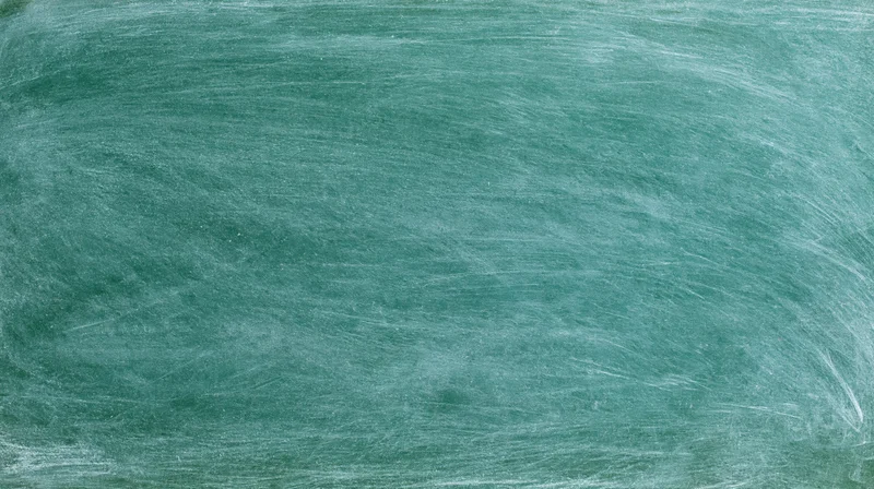 Empty green chalkboard surface with smudged white chalk marks filling the frame