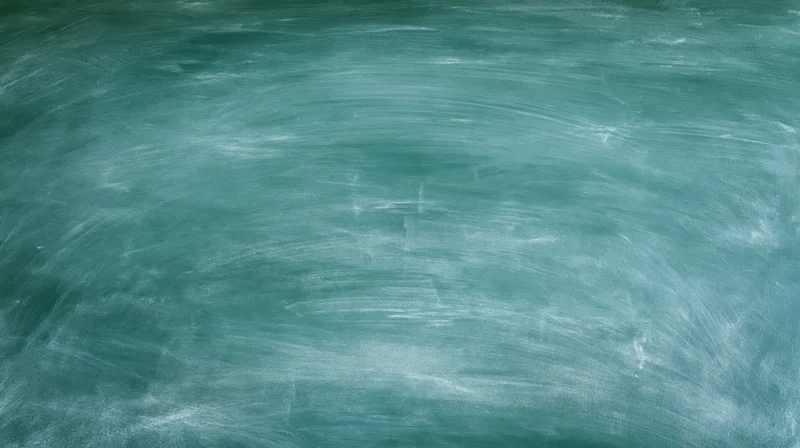 Empty green chalkboard surface with smudged white marks filling the frame