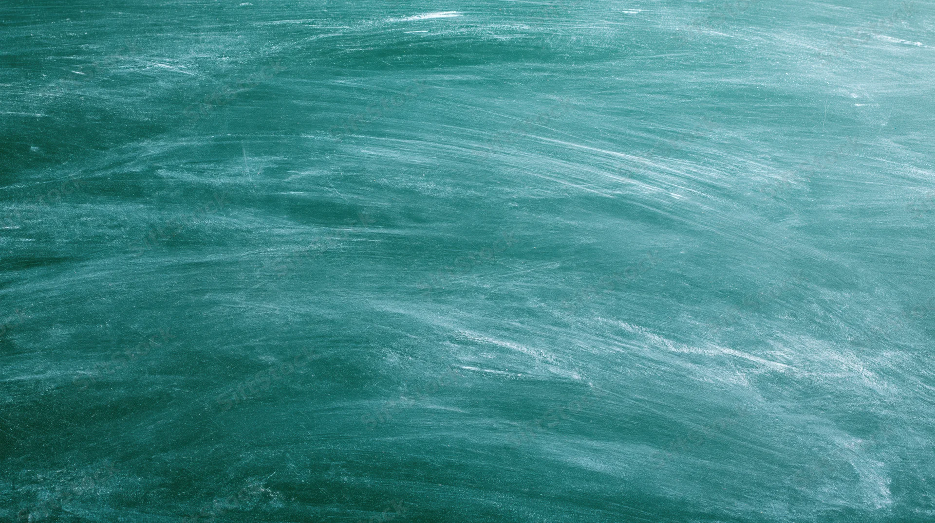 Empty green chalkboard surface filling the frame with smudged white chalk residue