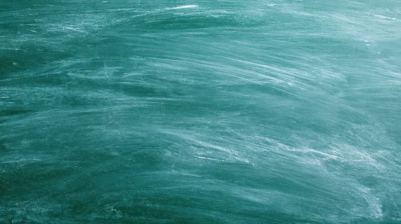 Empty green chalkboard surface filling the frame with smudged white chalk residue
