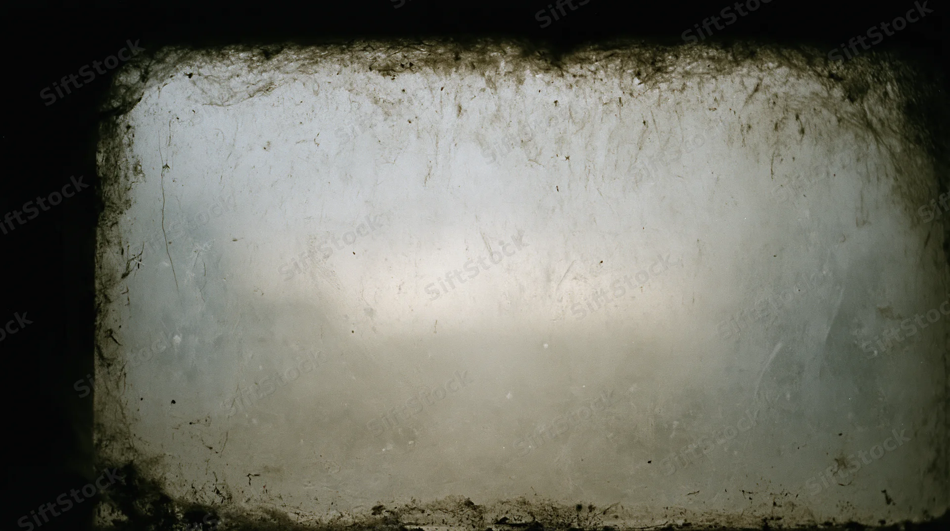Close-up of a dirty window pane covered in grime and streaks, showing signs of neglect and decay