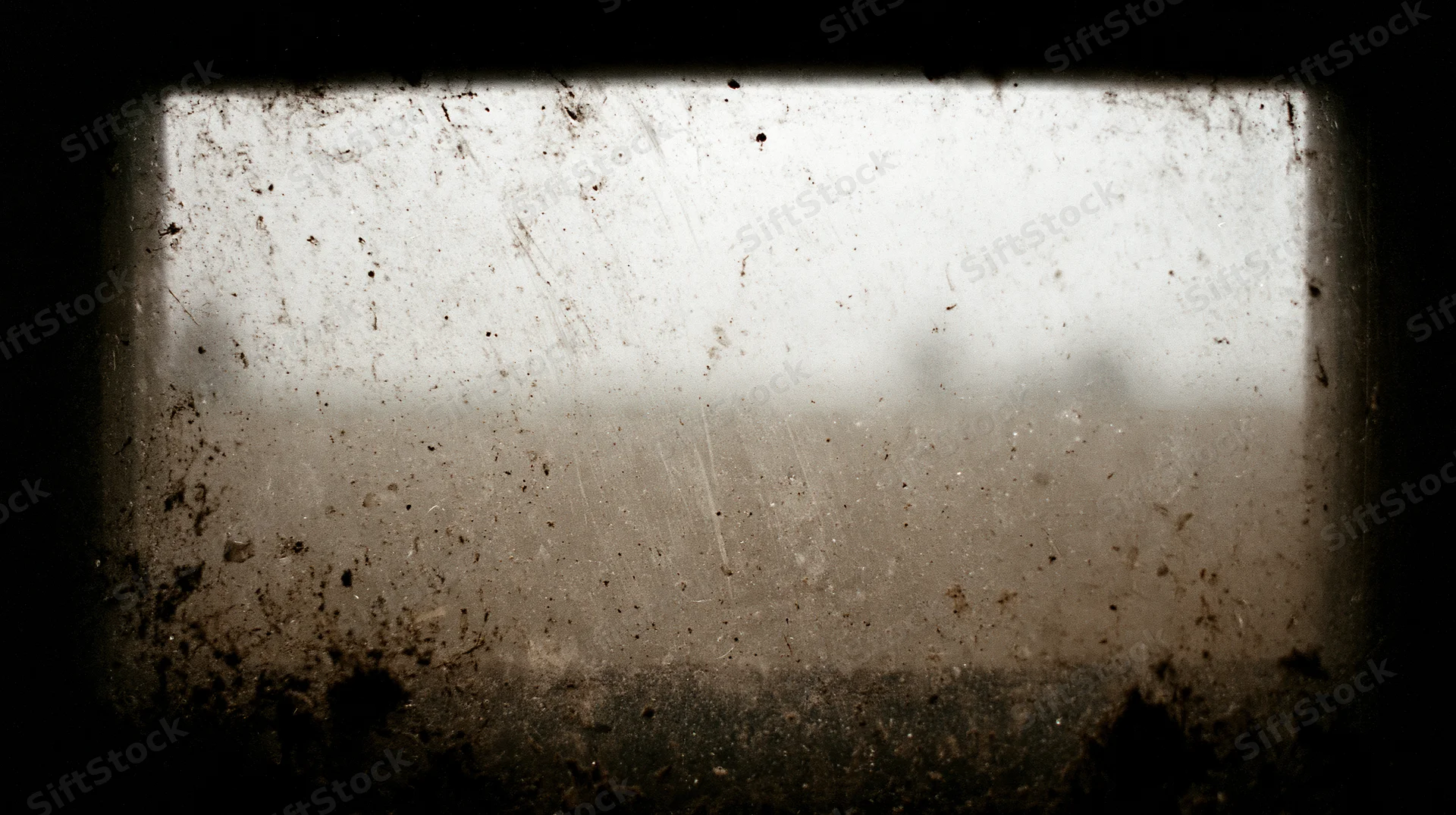 Dirty window pane covered in grime and scratches viewed from inside a dark space