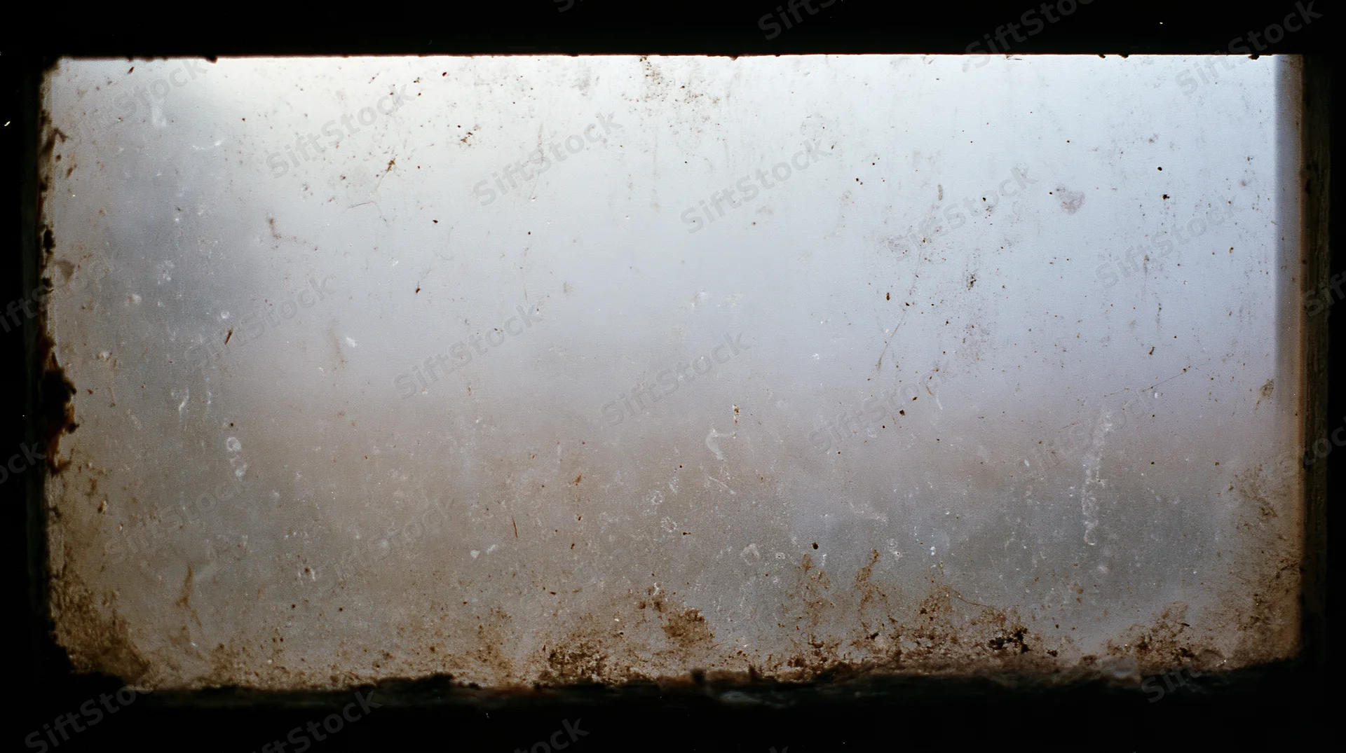 Dirty window pane covered in grime and dust showing signs of neglect and decay