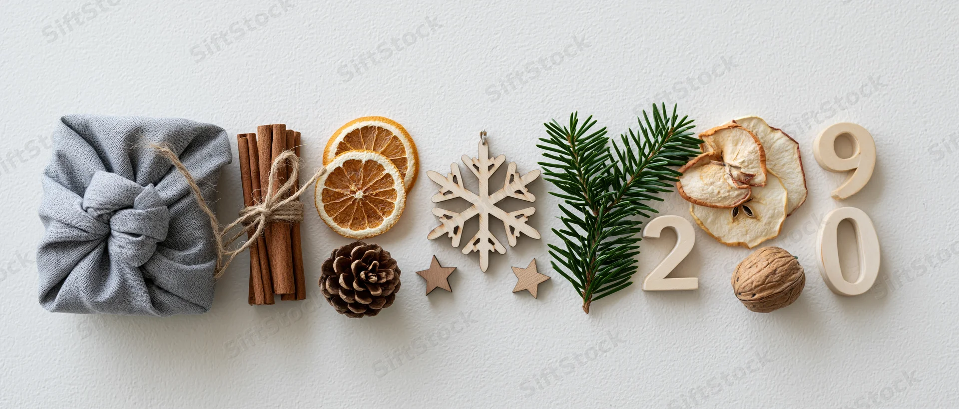 Natural christmas decorations arranged in a horizontal flat lay on white surface