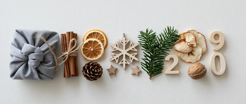 Natural christmas decorations arranged in a horizontal flat lay on white surface