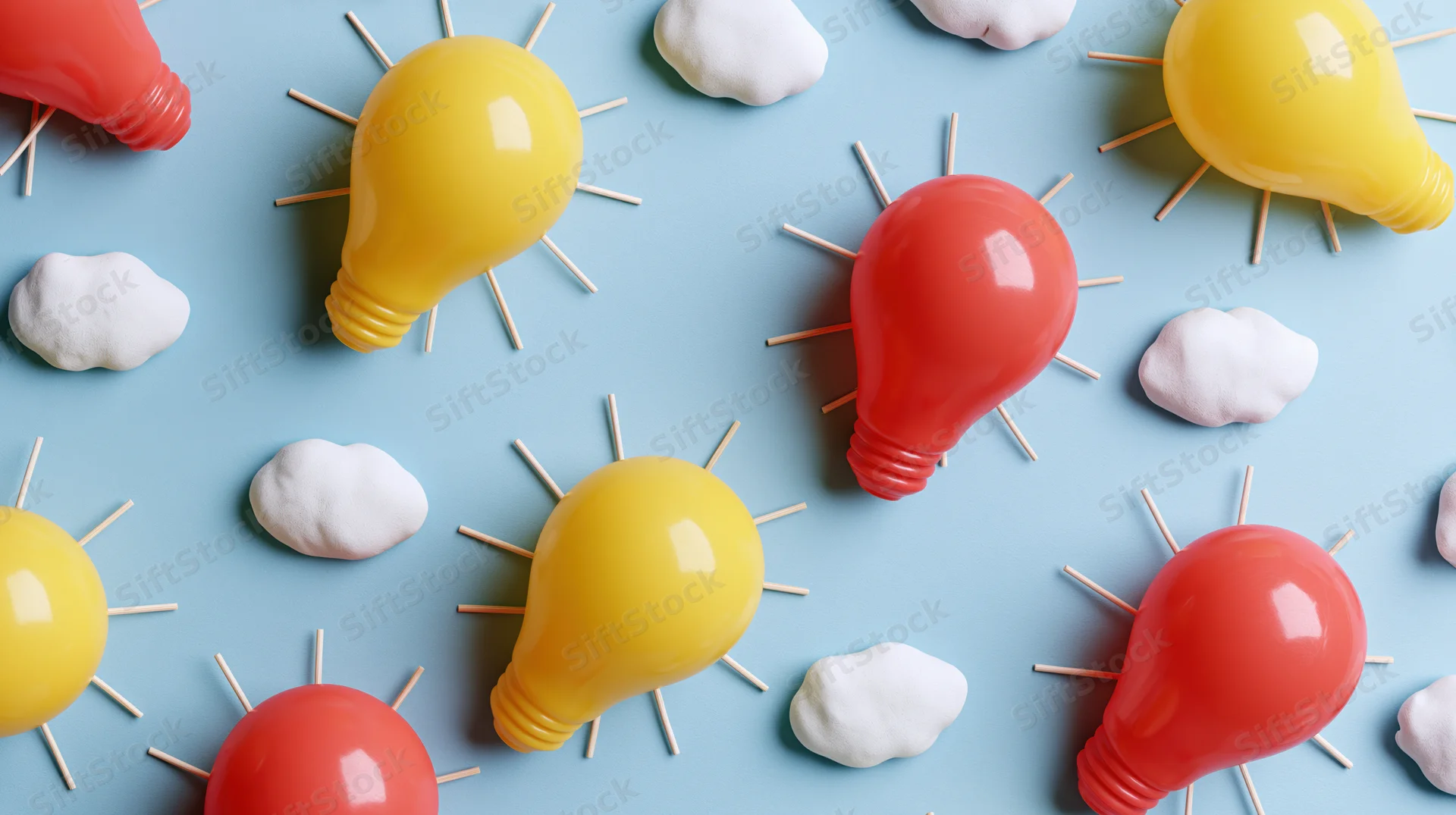 Colorful plastic lightbulbs and clouds arranged in a flat lay on a blue background