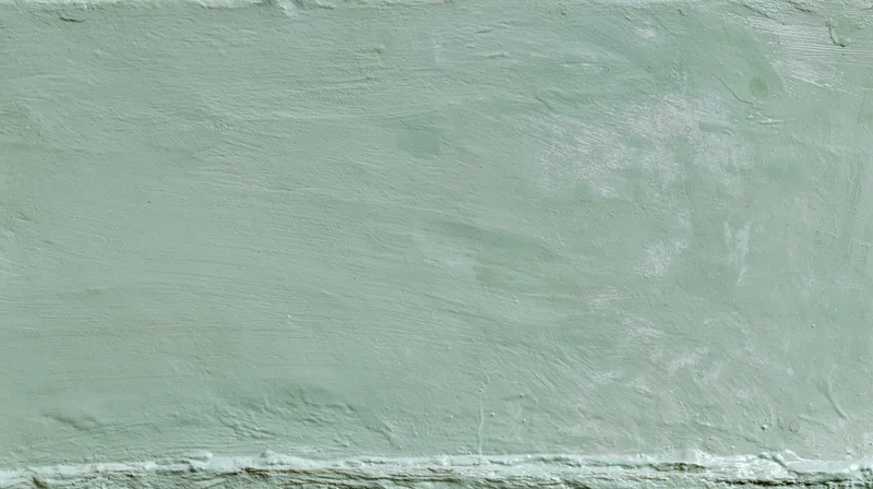 Textured green painted concrete wall surface filling the frame