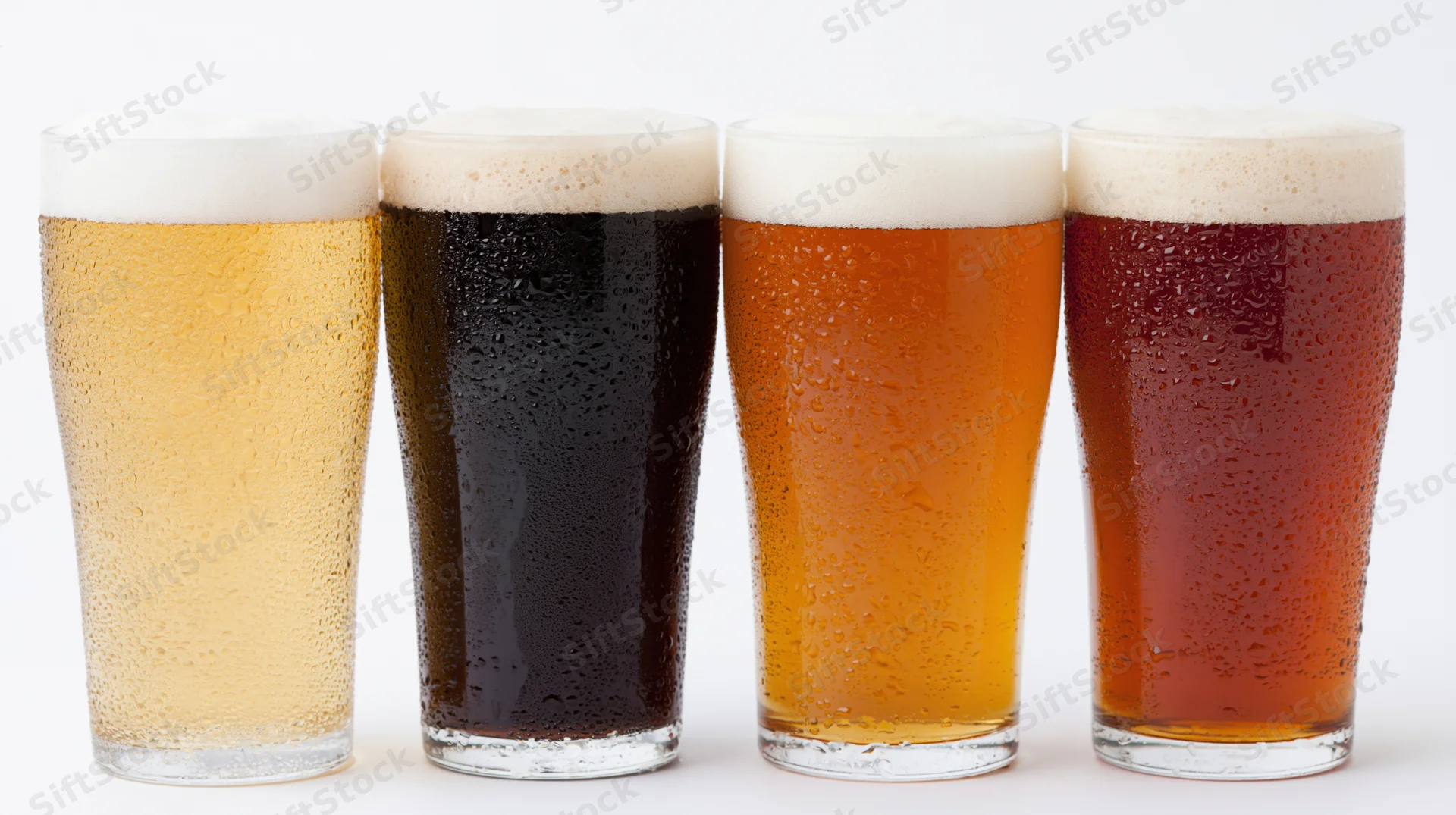 Four pint glasses of different beer varieties lined up in a row on white background