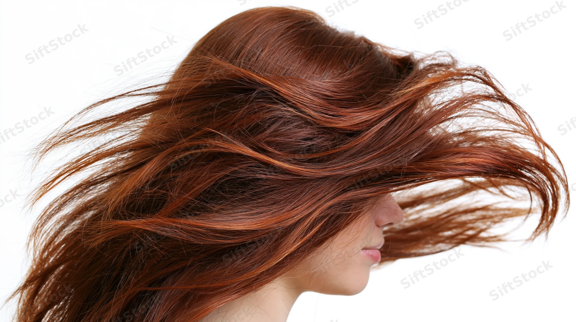 Woman with long flowing auburn hair in motion, side profile against white background