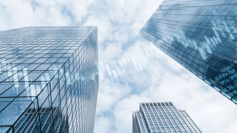 Low-angle view between glass skyscrapers under a cloudy sky with digital financial data overlaid on the facade