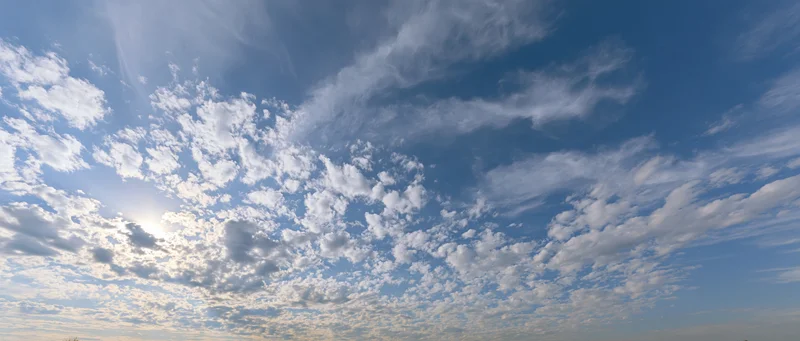 Open sky with scattered cumulus and wispy alto clouds during daytime