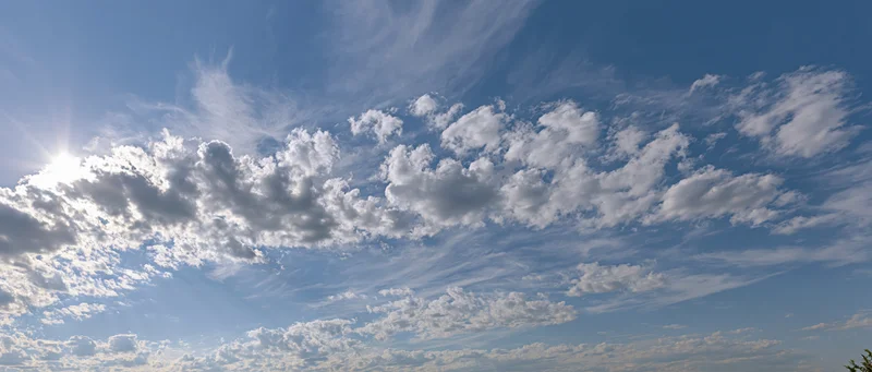 Open sky with scattered cumulus and wispy alto clouds during daytime