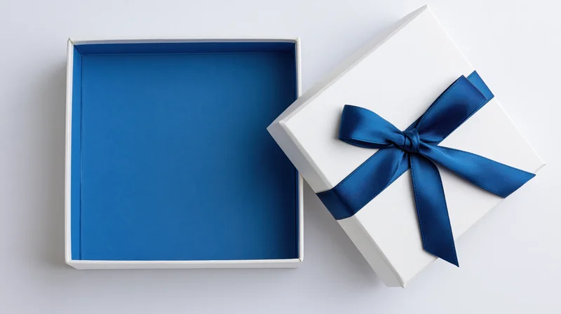 Open white gift box with blue satin ribbon bow, lid aside, revealing empty blue interior on white background
