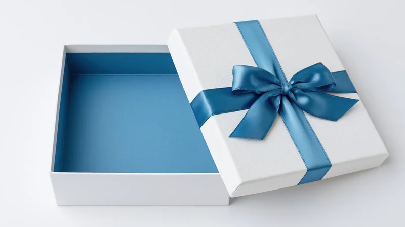 Open white gift box with blue ribbon bow and lid set aside revealing empty interior on white background