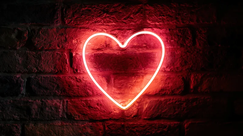 Red neon heart sign glowing on dark brick wall