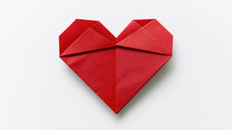 Red origami heart centered on white background