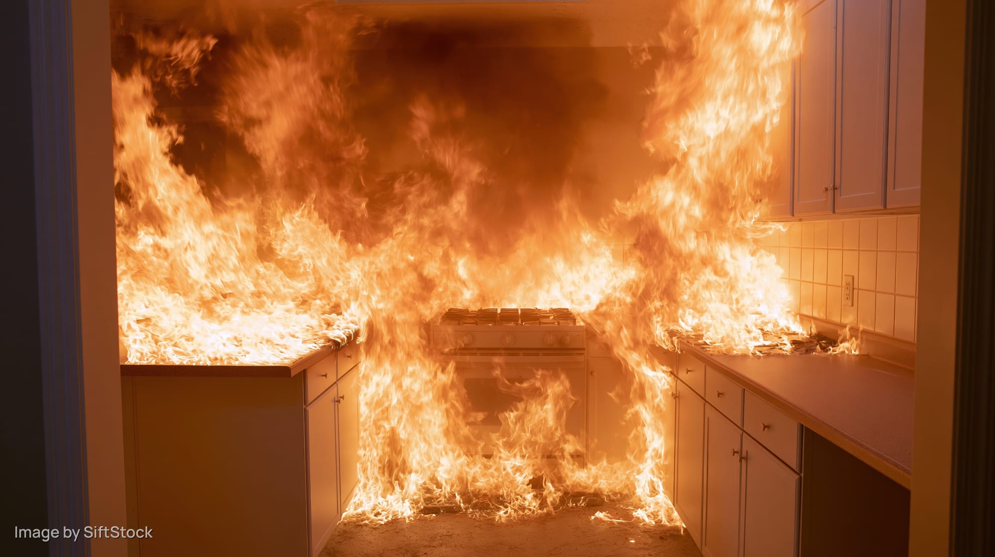 Kitchen engulfed in flames with cabinets and stove burning inside home