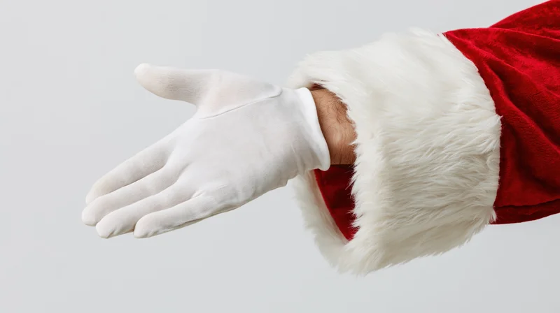 Santa's gloved hand extended palm down against white background