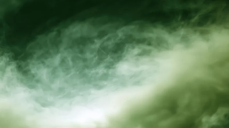 Swirling green-tinted smoke drifting across a plain background