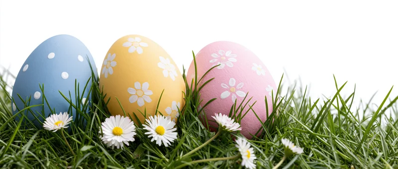 Three painted easter eggs with floral and polka dot patterns resting in green grass with daisies