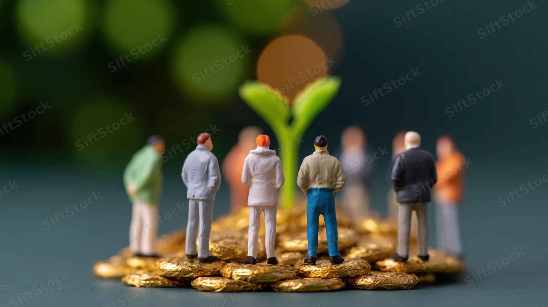 Miniature figurines of people standing around a mound of gold coins with a green sprout emerging from the center