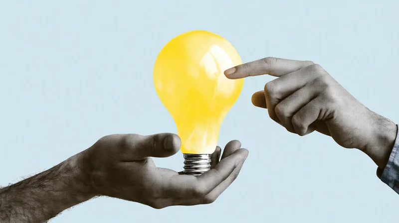 Two hands interacting with a glowing yellow lightbulb against a light blue background