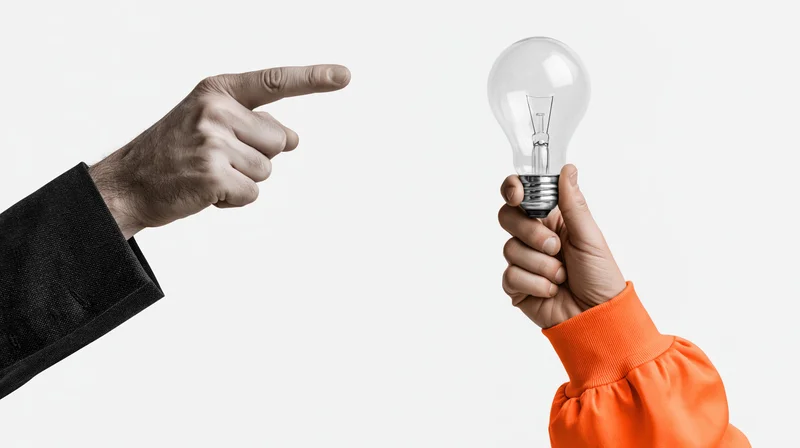 One hand pointing at another hand holding a lightbulb against white background