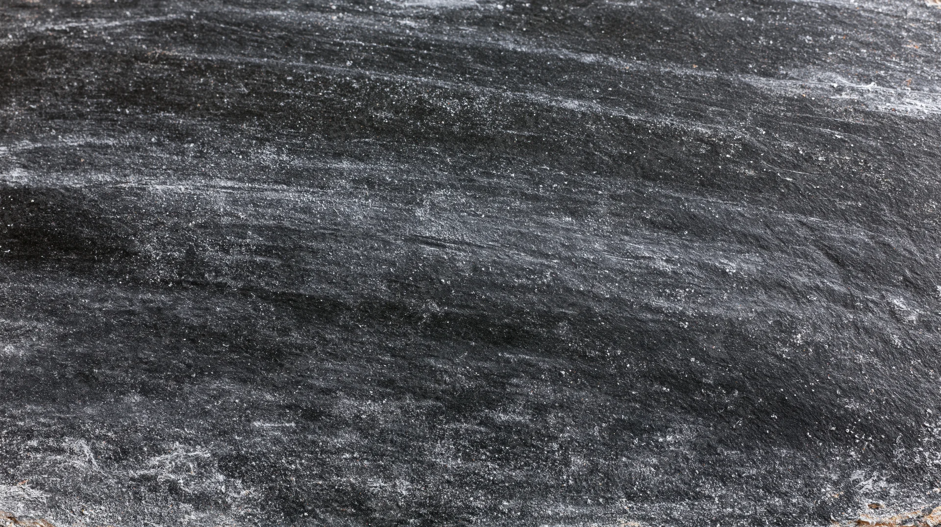 Worn blackboard surface with chalk residue and smudges, close-up view