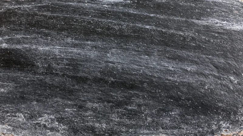 Worn blackboard surface with chalk residue and smudges, close-up view