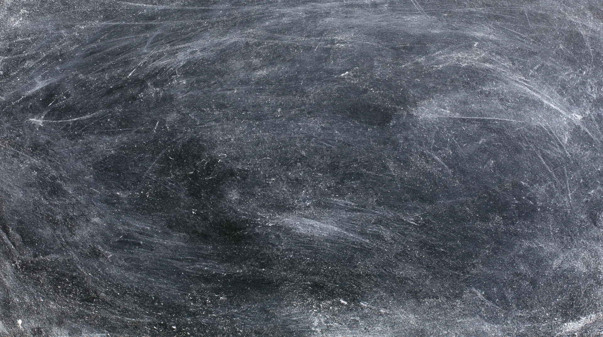 Worn blackboard surface with chalk residue and smudges, showing texture and use marks